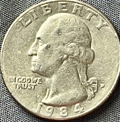 Side-by-side comparison of normal 1984-D quarter reverse vs 1984-D Spitting Eagle die break showing raised line from eagle beak