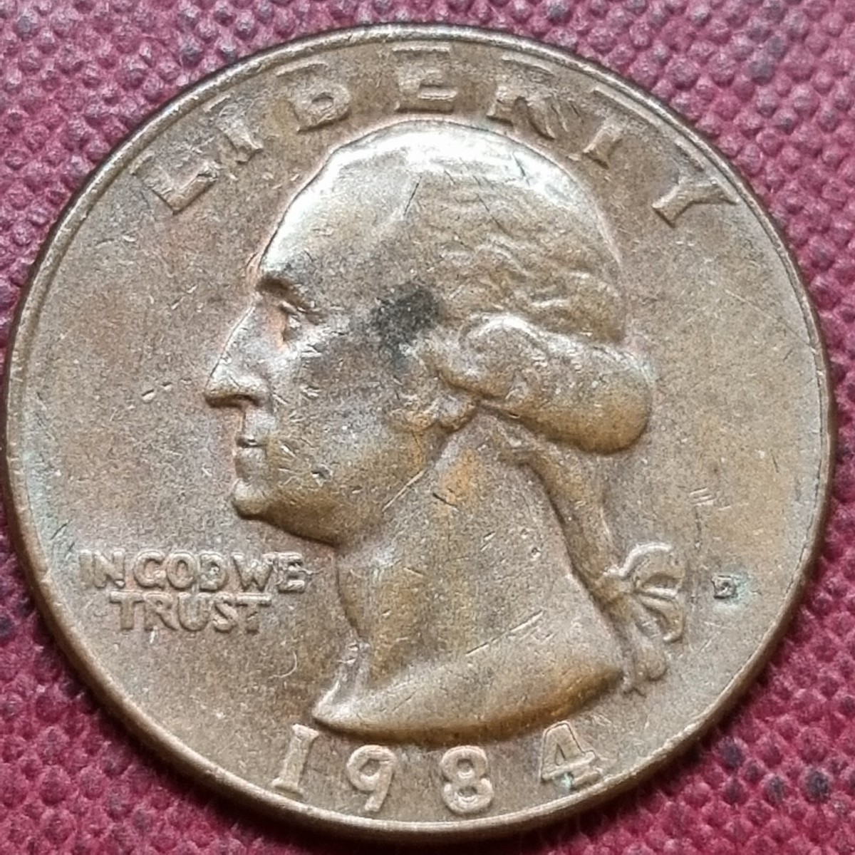 1984 quarter missing clad layer error showing copper core exposed on one face contrasting with normal silver-nickel clad on reverse